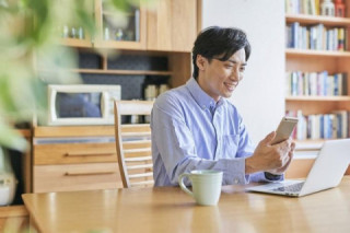 スマートフォンでホームページを見る男性 スマートフォンでホームページを見る男性